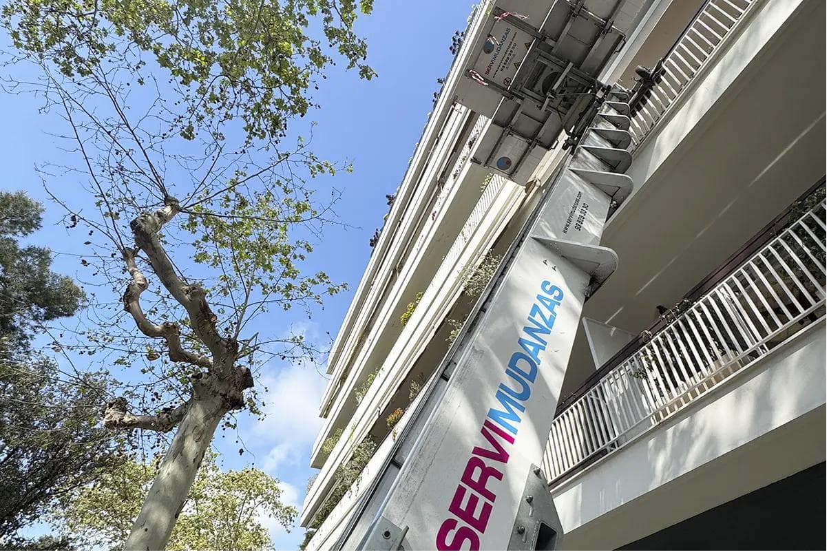 Plataforma elevadora de Servimudanzas trabajando por la fachada de un bloque, el sistema habitual en las mudanzas de Sant Ildefons (Cornellà)